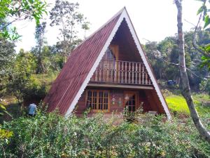 una pequeña casa con techo rojo en Recanto Mauá - Chalé Azaleia, en Visconde De Maua