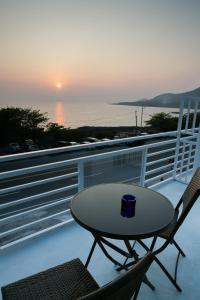 stół i 2 krzesła na balkonie z widokiem na zachód słońca w obiekcie 岸戀民宿 墾丁船帆石 w mieście Eluan