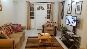a living room with two couches and a tv at Breezy Apts in Saint Philip