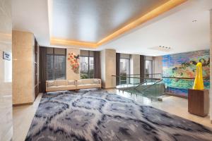 雅加达Ascott Sudirman Jakarta的一个带沙发和大地毯的大堂