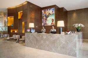 a room that has a table and a wall with paintings on it at Ascott Sudirman Jakarta in Jakarta