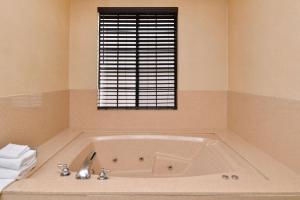 a bath tub in a bathroom with a window at Best Western Hollywood Plaza Inn Hotel - Hollywood Walk of Fame LA in Los Angeles +27 photos