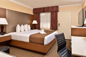 a hotel room with a bed and a chair at Best Western Hollywood Plaza Inn Hotel - Hollywood Walk of Fame LA in Los Angeles