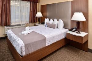 a hotel room with a large bed with towels on it at Best Western Hollywood Plaza Inn Hotel - Hollywood Walk of Fame LA in Los Angeles