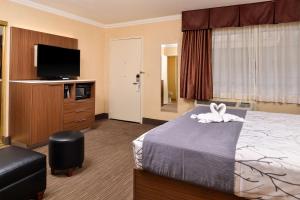 a hotel room with a bed and a flat screen tv at Best Western Hollywood Plaza Inn Hotel - Hollywood Walk of Fame LA in Los Angeles