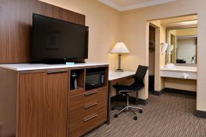 a hotel room with a television and a desk with a chair at Best Western Hollywood Plaza Inn Hotel - Hollywood Walk of Fame LA in Los Angeles
