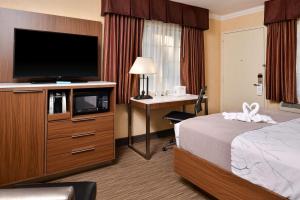 a hotel room with a bed and a desk with a television at Best Western Hollywood Plaza Inn Hotel - Hollywood Walk of Fame LA in Los Angeles