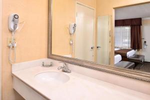 a bathroom with a sink and a mirror at Best Western Hollywood Plaza Inn Hotel - Hollywood Walk of Fame LA in Los Angeles