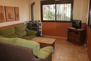 a living room with a couch and a tv at Rural Apartments overlooking the Lake. in Ardales