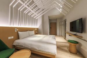 礁渓郷にあるHOTEL PIN Jiaoxiの大きな白いベッドとテレビのある寝室