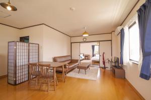 a living room with a table and chairs at Maru House in Uruma