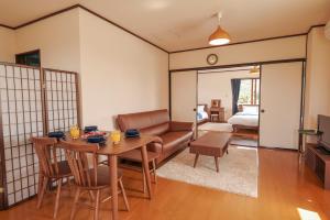 a living room with a table and a couch at Maru House in Uruma
