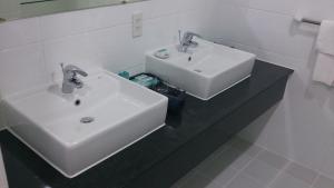 La salle de bains est pourvue d'un lavabo blanc et d'un miroir. dans l'établissement Saigon Sky Garden Serviced Apartments, à Hô-Chi-Minh-Ville