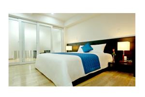 a bedroom with a large white bed with blue sheets at Saigon Sky Garden Serviced Apartments in Ho Chi Minh City