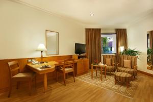 a hotel room with a desk and a television at Trident Chennai in Chennai