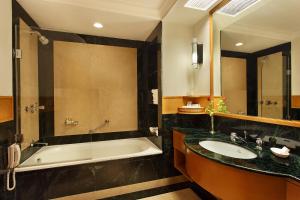 a bathroom with a bath tub and a sink at Trident Chennai in Chennai