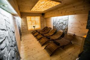 an empty room with chairs and a stone wall at Apartamenty przy skoczni in Szczyrk