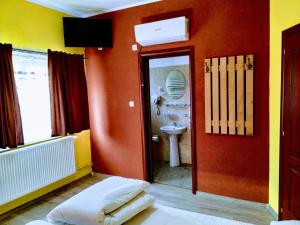 baño con aseo y pared roja en Venesis House, en Sighişoara