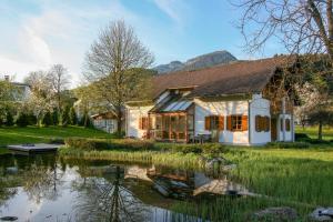 a house with a pond in front of it at Villa Anna Bad Goisern am Hallstättersee in Bad Goisern
