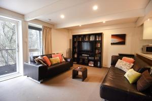 a living room with two couches and a tv at Maisonettes Falls Creek in Falls Creek