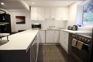 cocina con armarios blancos y encimera en Maisonettes Falls Creek, en Falls Creek