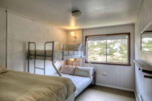a small bedroom with a bunk bed and a window at Maisonettes Falls Creek in Falls Creek