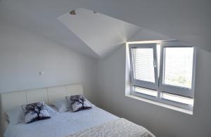 biała sypialnia z łóżkiem i oknem w obiekcie Apartmani Niko 05 w mieście Zadar