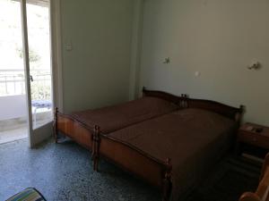 ルートラキにあるNatassa Apartmentの窓付きの部屋にベッド付きのベッドルーム1室があります。