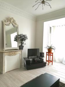 ein Wohnzimmer mit einem Spiegel und einem Tisch in der Unterkunft 6 Rue de Castillon Appartement in Beausoleil