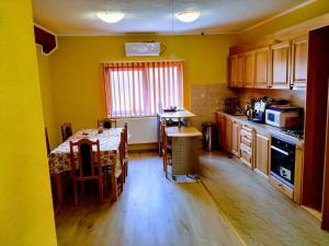 a kitchen with a table and a kitchen with yellow walls at Venesis House in Sighişoara