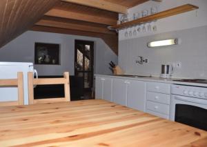 a kitchen with white cabinets and a wooden floor at Sklípek u kapličky in Velké Bílovice