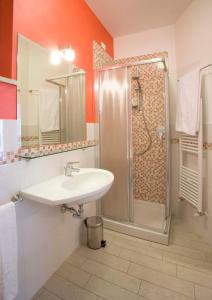 uma casa de banho com um lavatório e um chuveiro em La Perla Del Conero Affittacamere em Numana