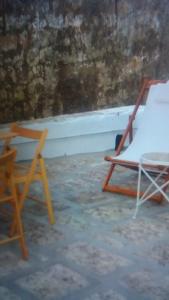 2 chaises assises à côté d'un mur de briques dans l'établissement La municeddha, à Cannole