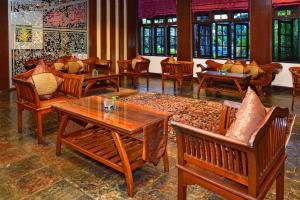 sala de estar con mesas, sillas y ventanas en Holiday Villa Beach Resort Cherating, en Cherating
