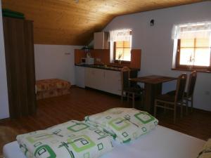 1 dormitorio con 2 camas y cocina con mesa en Apartmán Pohoda, en Nový Přerov