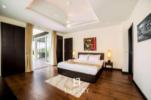a bedroom with a bed and a sliding glass door at 5 Bedroom Amazing Pool Villa In Resort TS1 in Hua Hin +37 photos