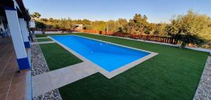 a swimming pool in a yard with green grass at Monte Família Ferreira in Vale de Açor