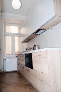 a kitchen with wooden cabinets and a stove at Rodmos Hostel in Lublin