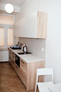 a kitchen with wooden cabinets and a stove top oven at Rodmos Hostel in Lublin