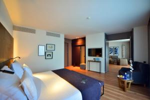 a hotel room with a bed and a living room at Barceló Sevilla Renacimiento in Seville