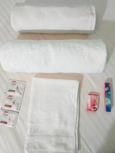 una pila de toallas y un rollo de papel higiénico en Royal Guest House, en Calcuta