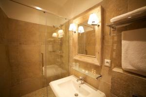 a bathroom with a sink and a shower and a mirror at La Maison d'Emilie in Houlgate