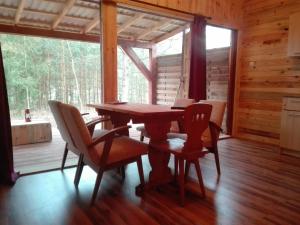 ein Esszimmer mit einem Tisch und Stühlen in einer Hütte in der Unterkunft Maly Domek Zalesie in Barczewo