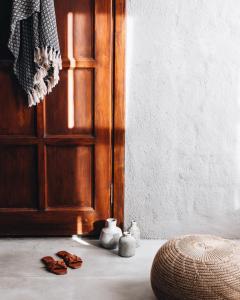 a room with a wooden door and a pair of shoes at GAIA ALAÇATI in Alaçatı