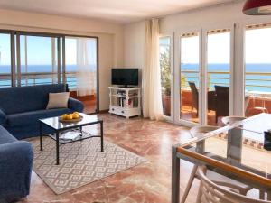 een woonkamer met een blauwe bank en een tv bij Apartamento Leo Playa de San Juan in Alicante