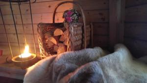 a basket of fire wood and a candle and a blanket at Motelli Rovaniemi in Rovaniemi