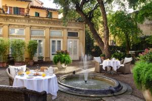 a fountain in the middle of a courtyard with tables at Al Palazzo del Marchese di Camugliano Residenza d'Epoca in Florence
