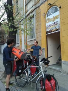 dos hombres parados junto a una bicicleta delante de un edificio en Hostel Ginger House en Plovdiv