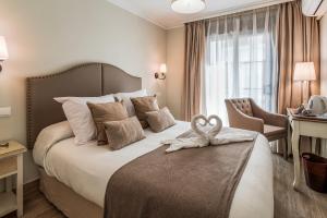 a hotel room with a bed with a towel on it at Hostal Boutique Plaza Cantarero in Nerja