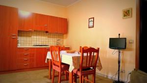 a kitchen with a table and chairs and a television at B&B Lu Palummaru in Palmariggi